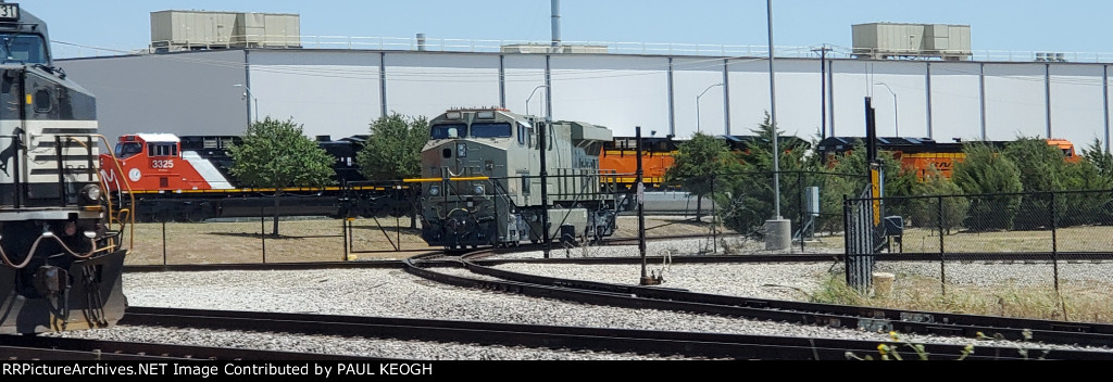 A primered BNSF 3283 (ES44ACH Tier 4 Credit) with CN 3325 (AC44C6M), BNSF 3667 and BNSF 3668 (ET44ACH's) in the Background..